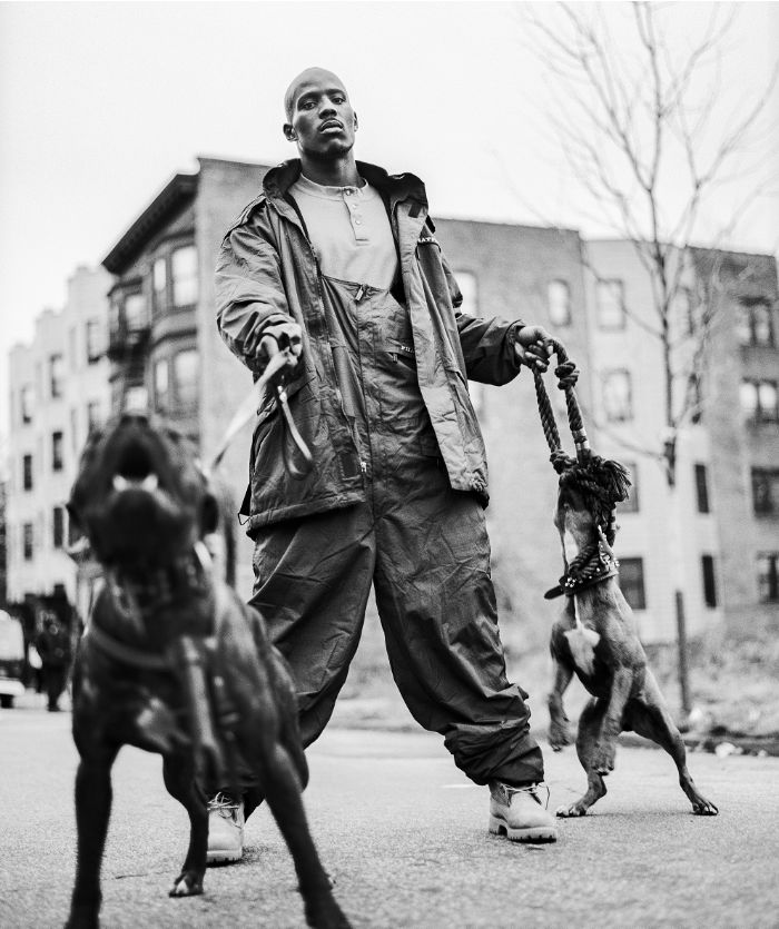 DMX on a city street, hold the leashes of two pit bulls
